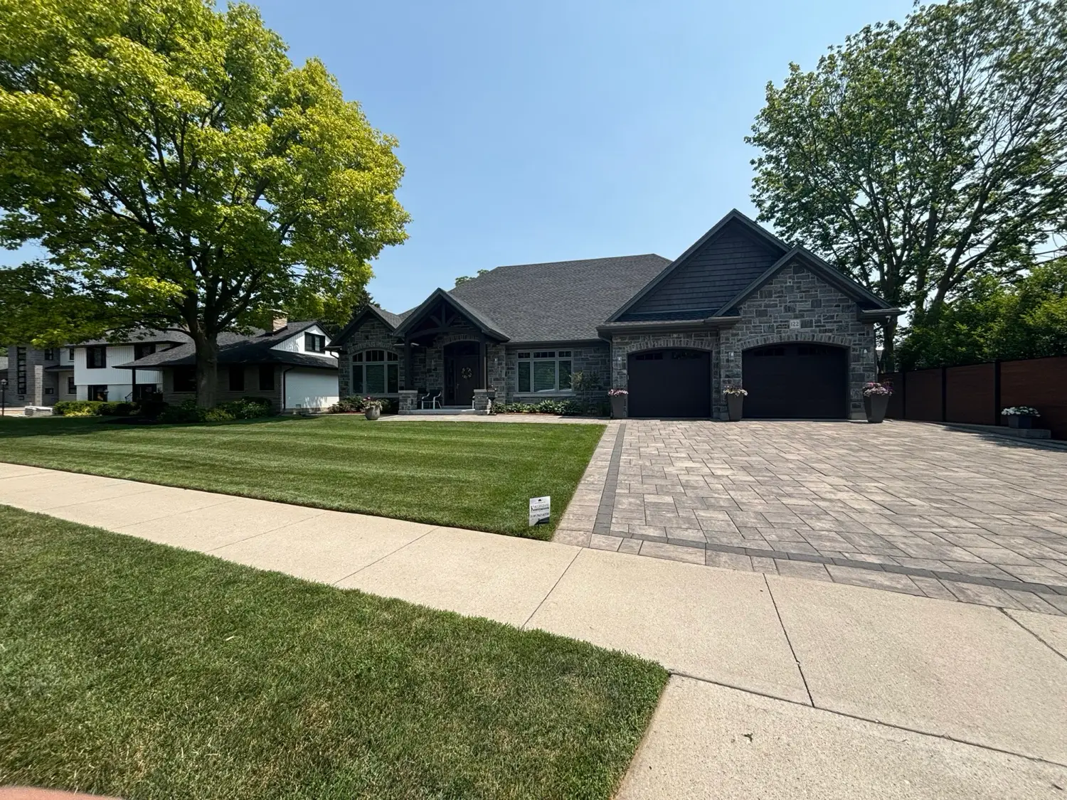 Healthy green lawn in front of a stone home