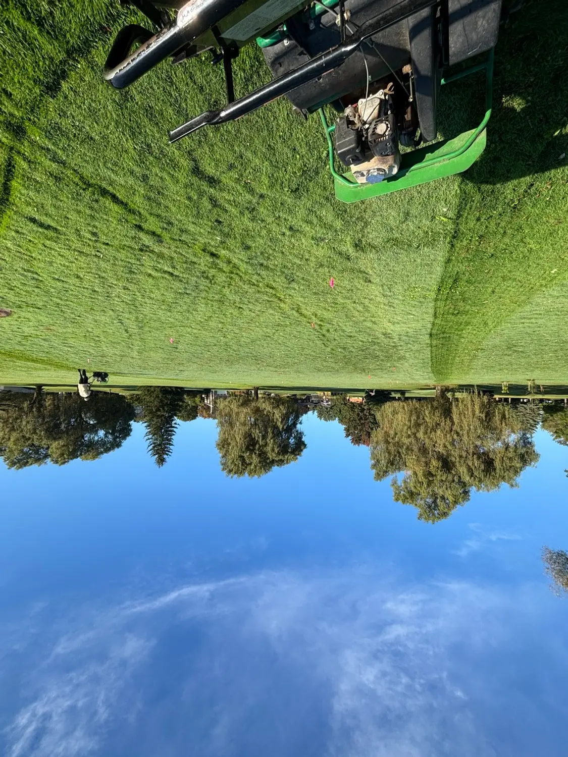 Mowing a healthy lawn under a clear blue sky